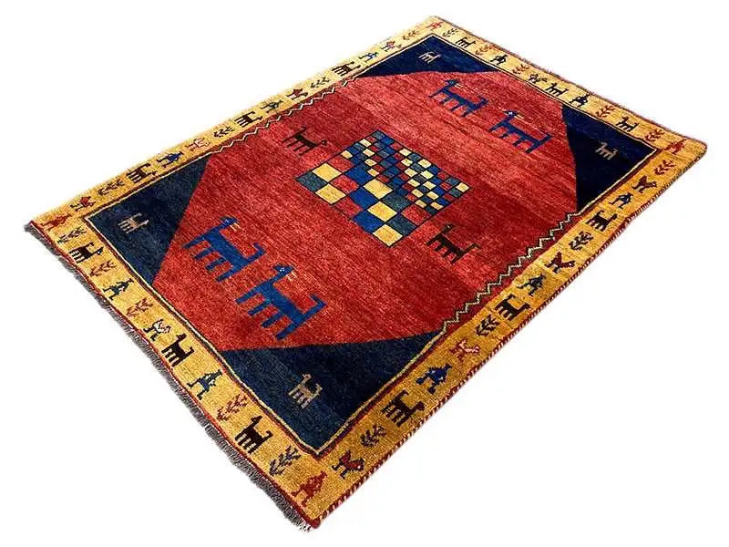 Gabbeh rug: red center with blue and yellow decorative motifs and a yellow border