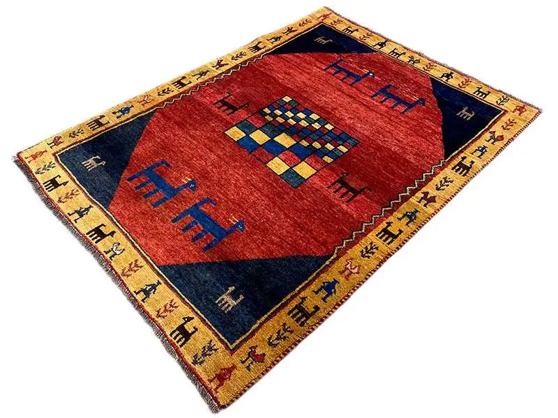 Gabbeh rug: red center with a blue border and colorful geometric motifs