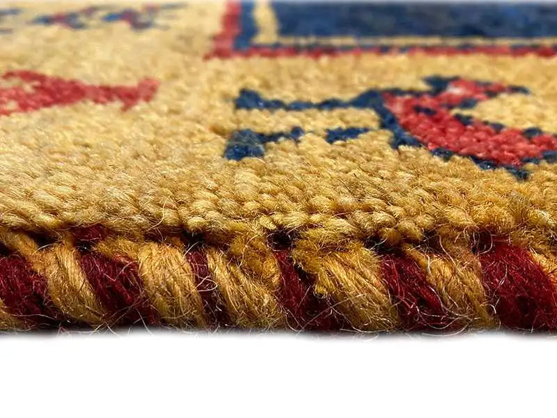 Gabbeh rug detail: pile texture in red and beige tones with a blue pattern