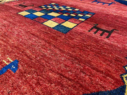 Gabbeh rug detail: red fabric with a blue-and-yellow checked ornament