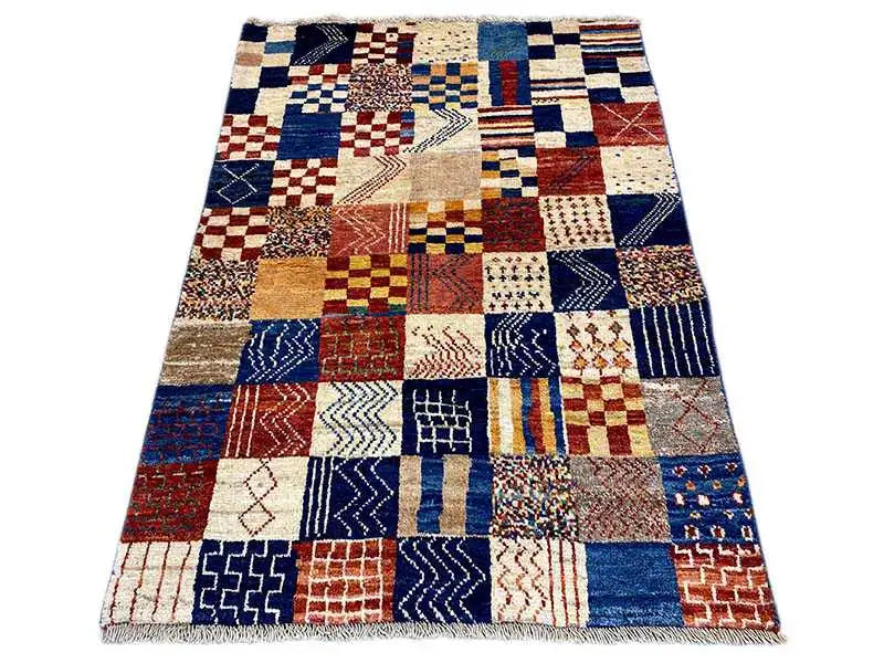 Gabbeh rug with a blue, red, and cream patchwork pattern, rectangular (141×98 cm)