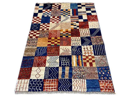 Gabbeh rug with a blue, red, and cream patchwork pattern, rectangular (141×98 cm)