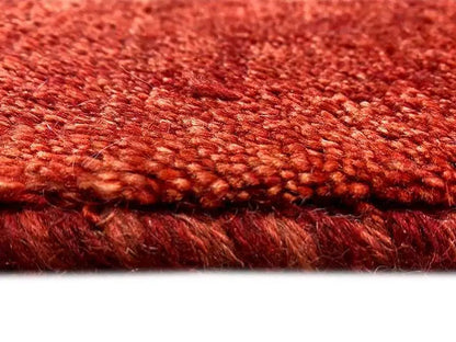 Close-up: Reddish-brown carpet with mottled short pile and visible edge