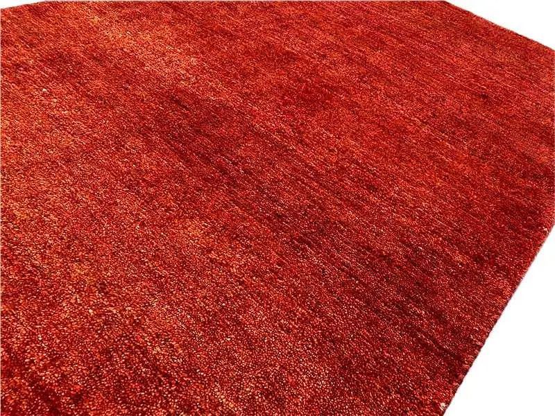Surface of the Gabbeh rug in reddish brown with a dense, mottled weave texture