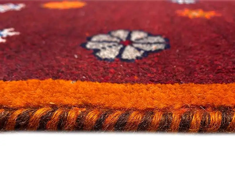 Close-up: dark raw pile with an orange carpet edge