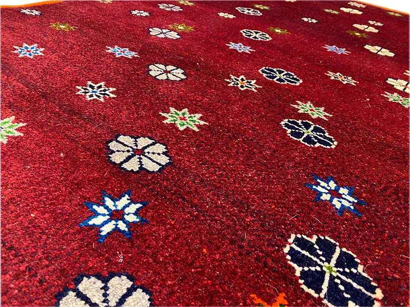 Close-up: dark red pattern of multicolored stars and flowers