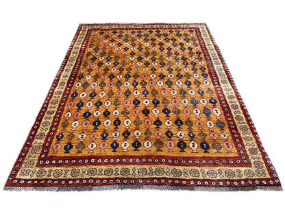 Gabbeh rug with a wide red and brown border and a dense diamond pattern in the center