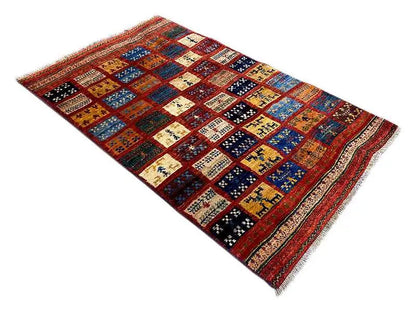 Rectangular Gabbeh rug with colorful patterned squares, a colorful border, and fringes