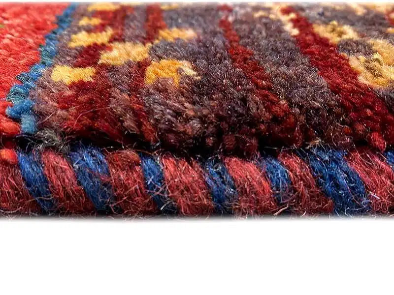 Close-up of the floral pattern and carpet pile with dense, colorful yarn and a fringed edge