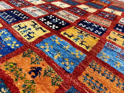 Close-up: colorful Gabbeh rug motifs in squares with shades of red, blue, and yellow