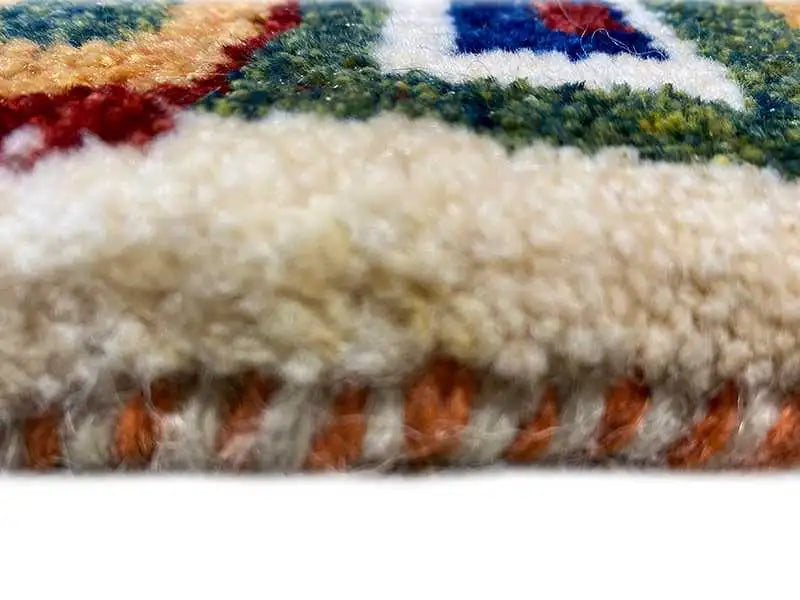 Gabbeh rug pile with colorful embroidery and fringed edges