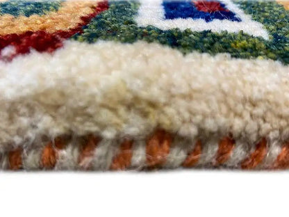 Gabbeh rug pile with colorful embroidery and fringed edges