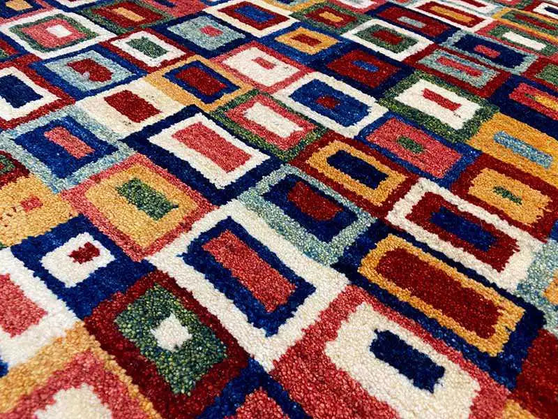 Gabbeh rug detail: colorful square pattern, white, blue, and red areas