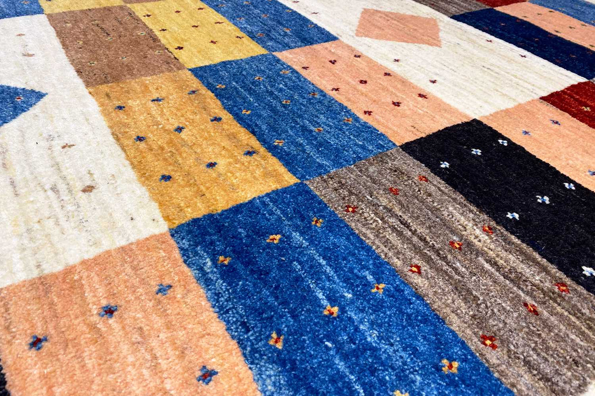 Close-up of a Gabbeh rug: colorful blocks with fine dots in the pile