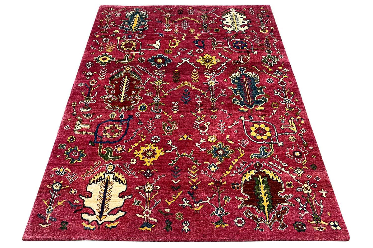Red Gabbeh rug with a colorful pattern, spread at an angle