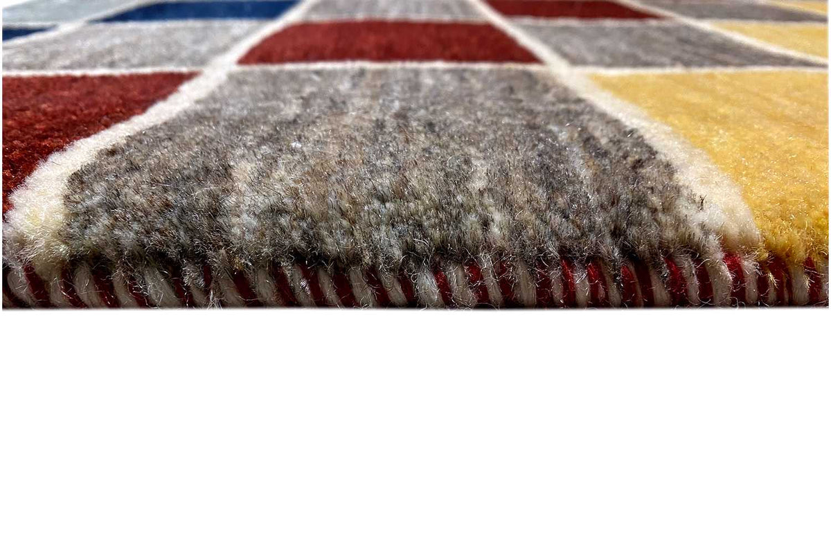 Close-up of Gabbeh rug: edge with short fringe and multicolored checks