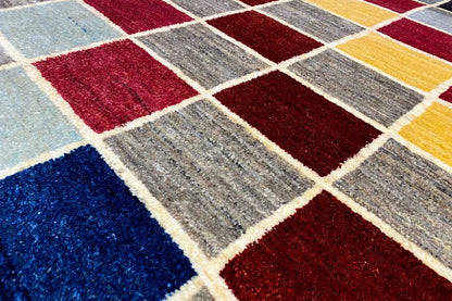 Gabbeh rug detail with short pile and a contrasting checkered pattern in blue, red, and gray