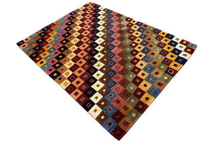 Gabbeh rug in a diagonal view, geometric tile pattern in blue, red, green, and beige
