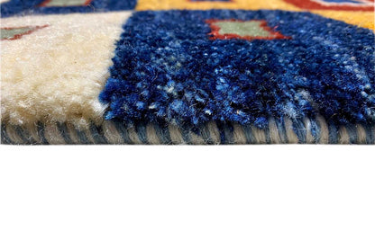 Gabbeh rug close-up: short pile and fringe at the edge, blue and cream