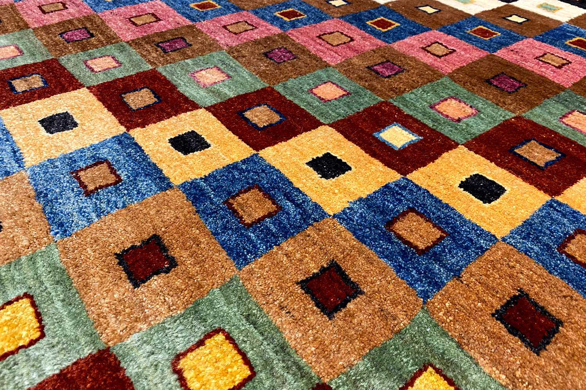 Gabbeh rug close-up: colorful square motifs in the pile, blue, orange, and green