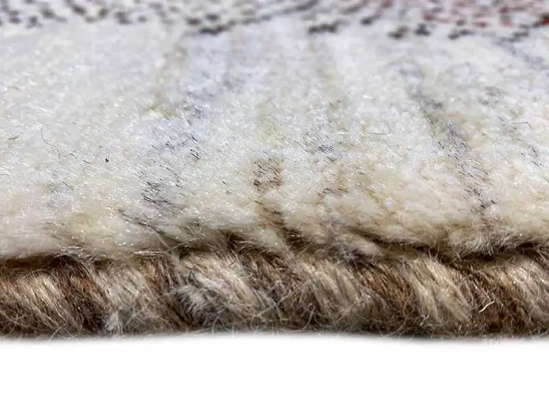 Close-up of Gabbeh rug: beige pile with a dense, dark border texture