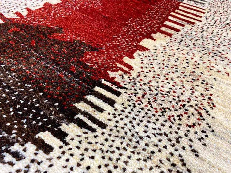 Gabbeh rug detail: beige dotted texture with a red area and black stripes