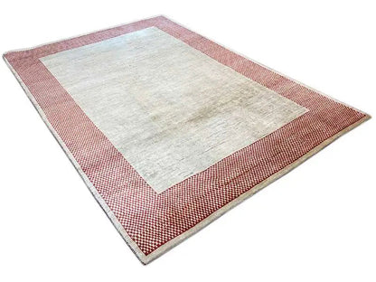 Gabbeh rug laid out: beige central field, red-and-white checkered pattern along the edge