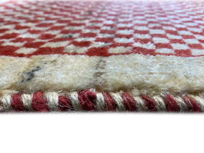 Rug border with short fringes and a red-and-white check pattern, beige center field