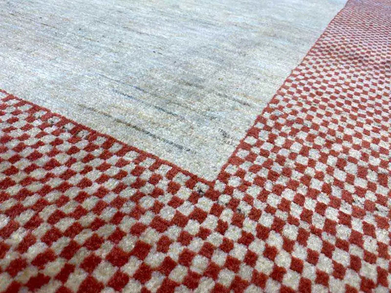 Detail view: red-and-white checkered pattern around the edge and beige inner field