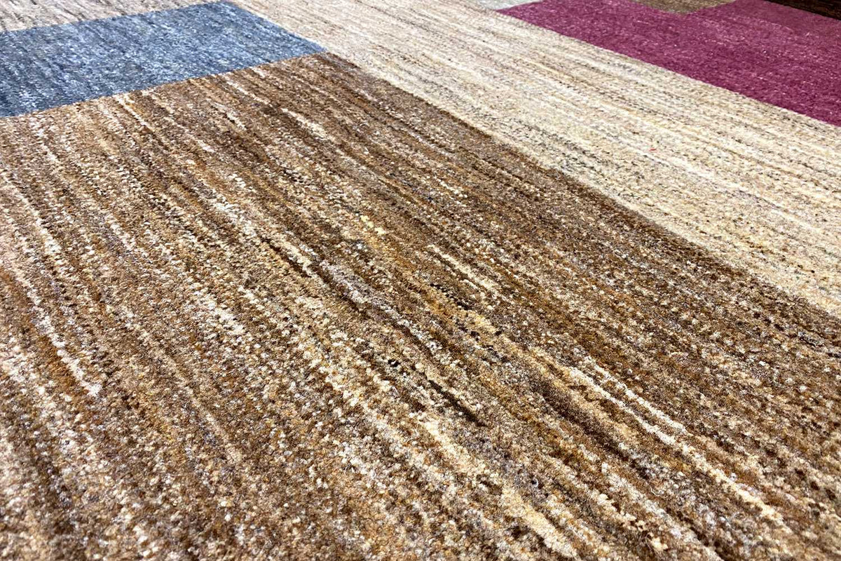 Close-up of carpet pile: brown-beige fibers with a fine longitudinal structure