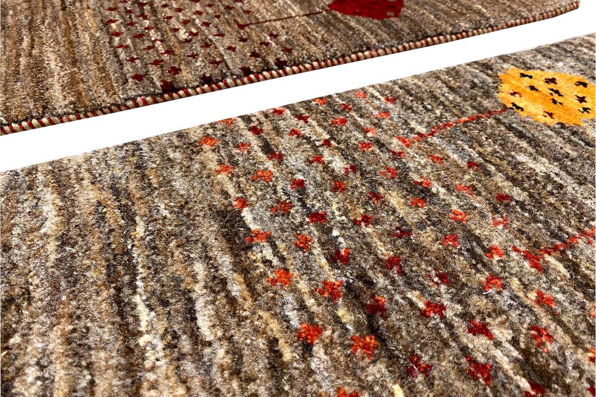 Close-up view of a 40x60 cm brown Gabbeh rug with multicolored embroidered dots and a ribbed pattern