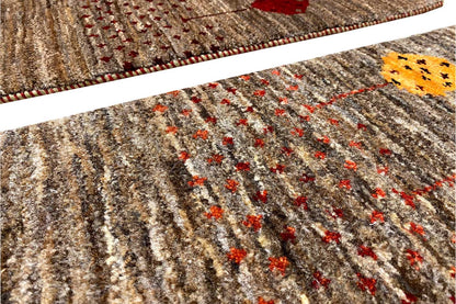 Close-up view of a 40x60 cm brown Gabbeh rug with multicolored embroidered dots and a ribbed pattern