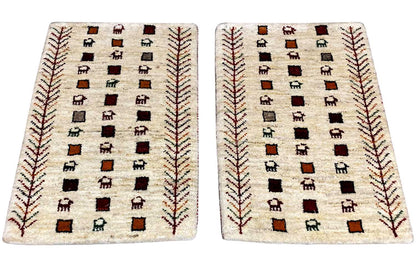 Gabbeh rug, cream-colored with a geometric square pattern featuring figures and red decorative lines