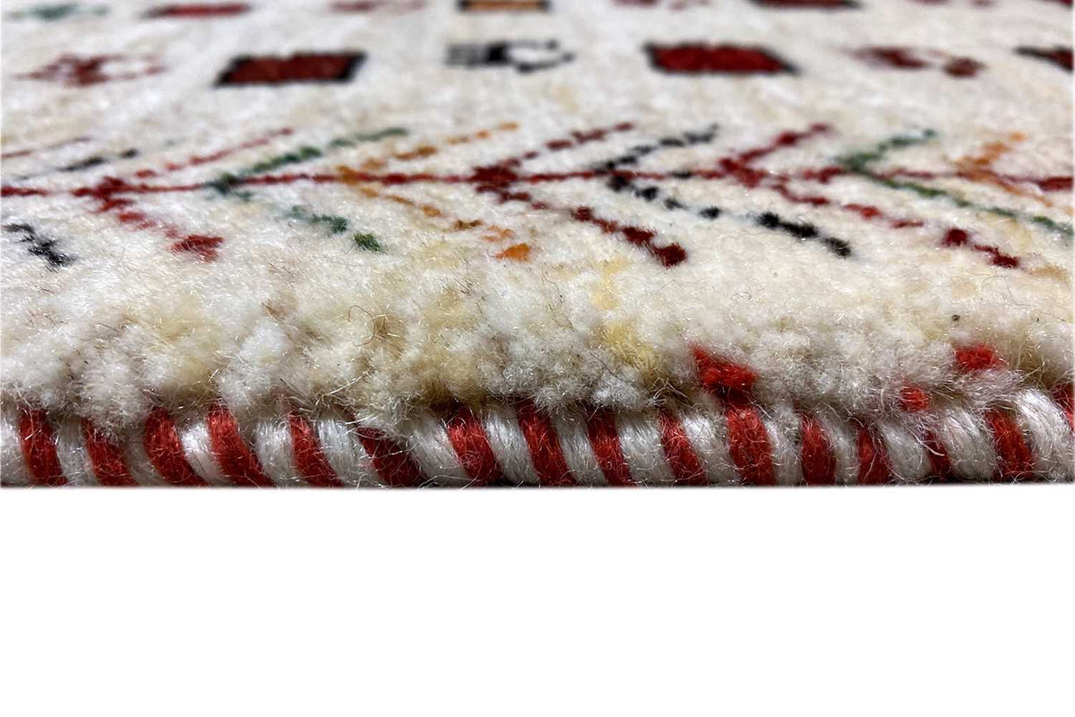 Gabbeh rug, cream-colored pile with red fringes and a colorful embroidered pattern