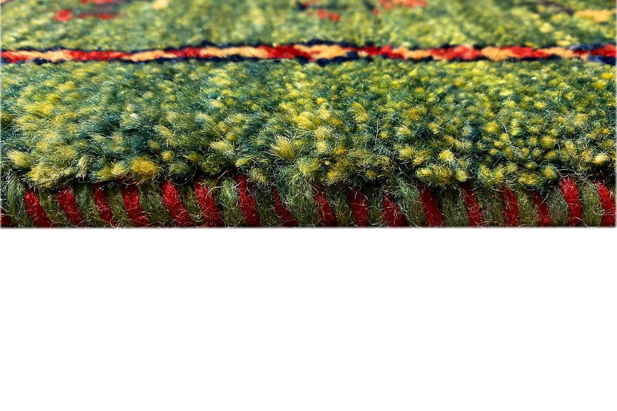Gabbeh rug, detail of the pile surface in green/yellow with a red-bordered edge