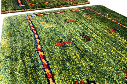 Gabbeh rug, close-up of green pile with a red border and multicolored linear pattern