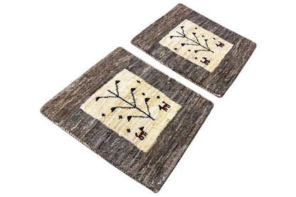 Gabbeh rug with a beige field and black tree motif, gray wool ground