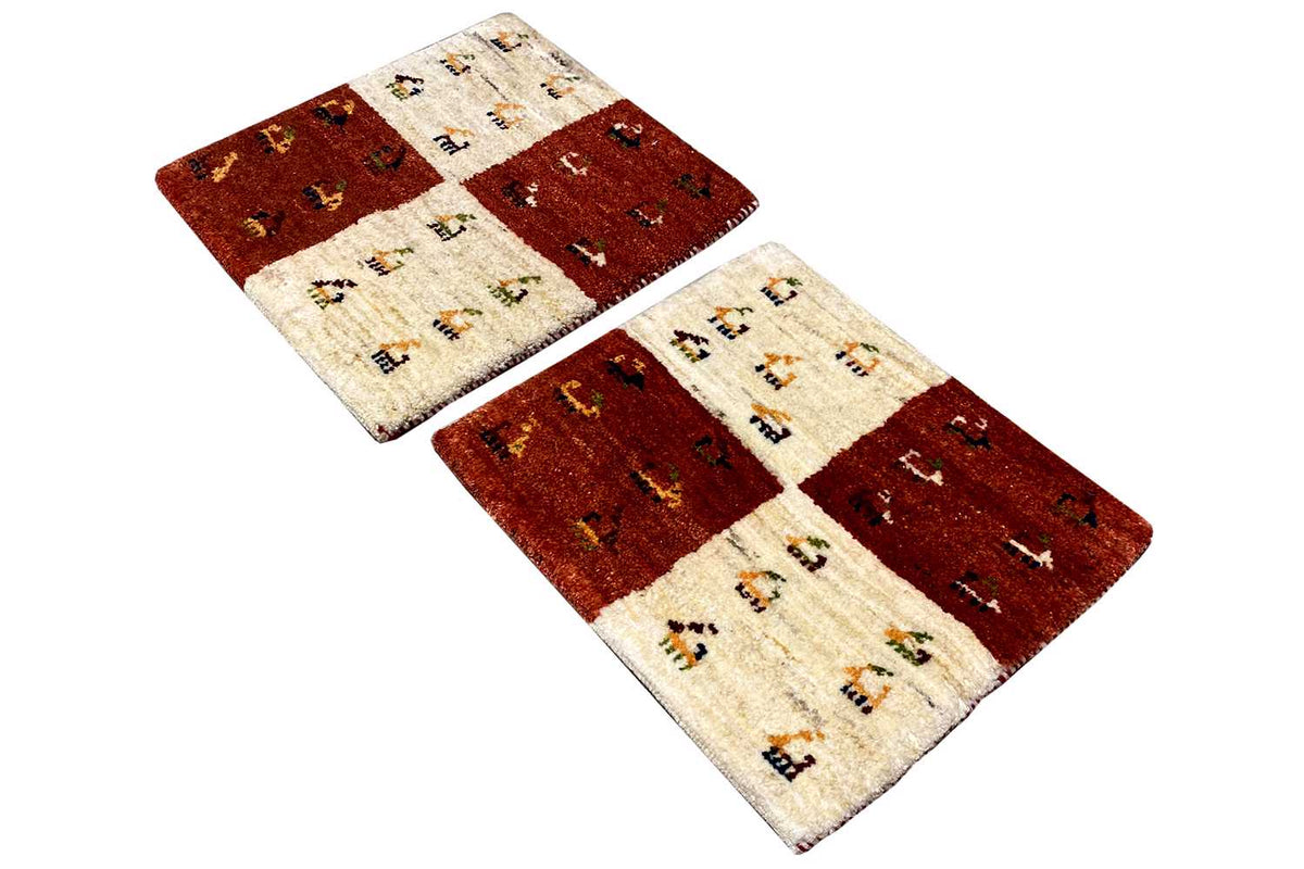 Rectangular Gabbeh rug, reddish-brown and cream-colored areas, with decorative elements