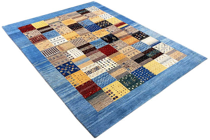 Geometric Gabbeh rug with corner view: blue border, patchwork of tiles in multiple colors