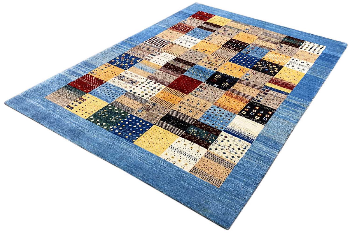 Geometric Gabbeh rug at an angle, blue-framed patchwork with colorful quadrilaterals