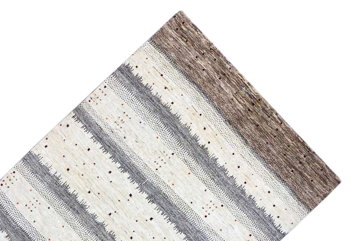 Gabbeh rug corner with horizontal gray-beige stripes and a brown base area