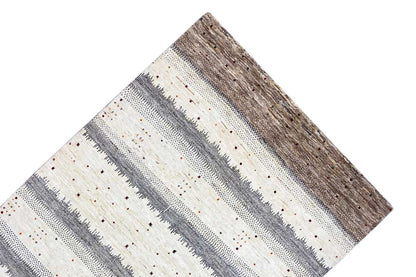 Gabbeh rug corner with horizontal gray-beige stripes and a brown base area