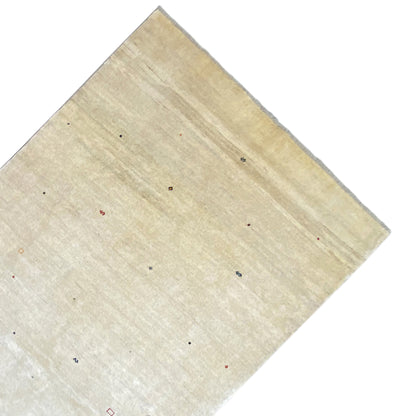 Beige Gabbeh rug spread out, with small colorful dots and a narrow border.
