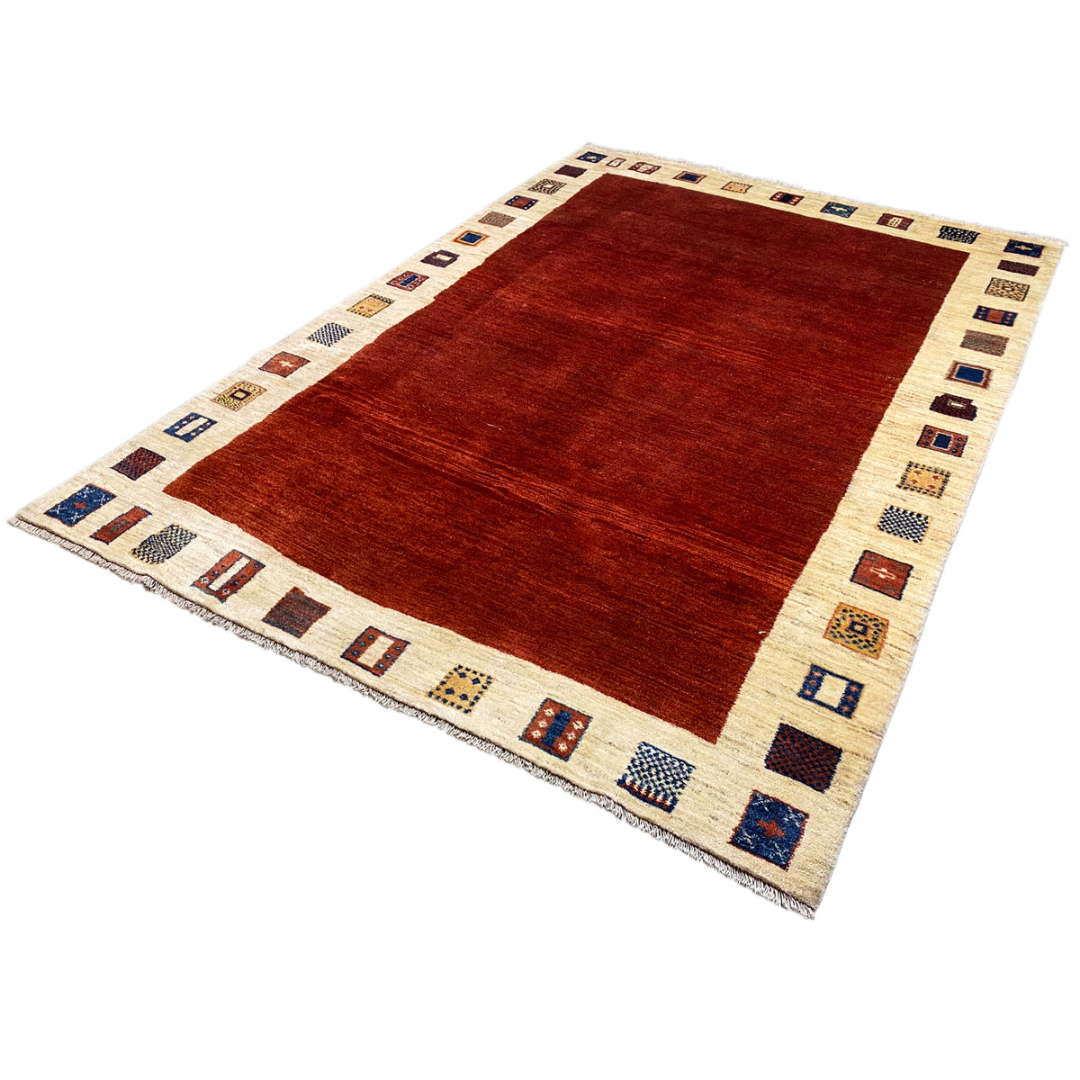 Gabbeh rug from an oblique perspective: red center, beige border with blue-red squares