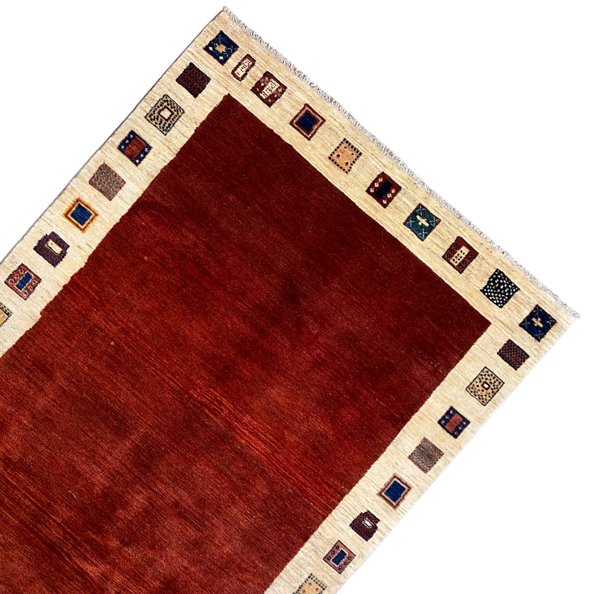 Gabbeh rug corner: red central section, beige border with blue-and-gold ornamental squares