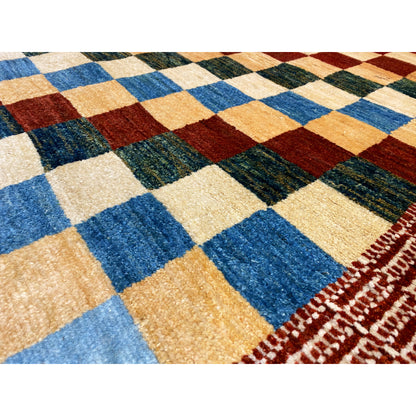 Gabbeh rug detail view: woven squares in blue, beige, green, and brown