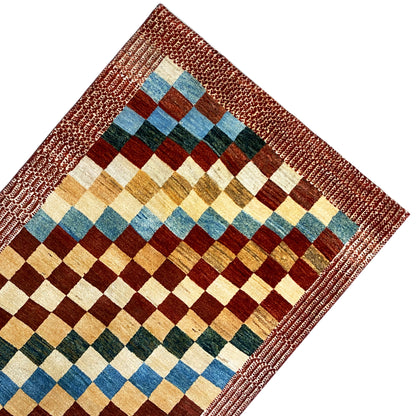 Gabbeh rug with a reddish-brown border and a checked pattern in blue, green, and yellow
