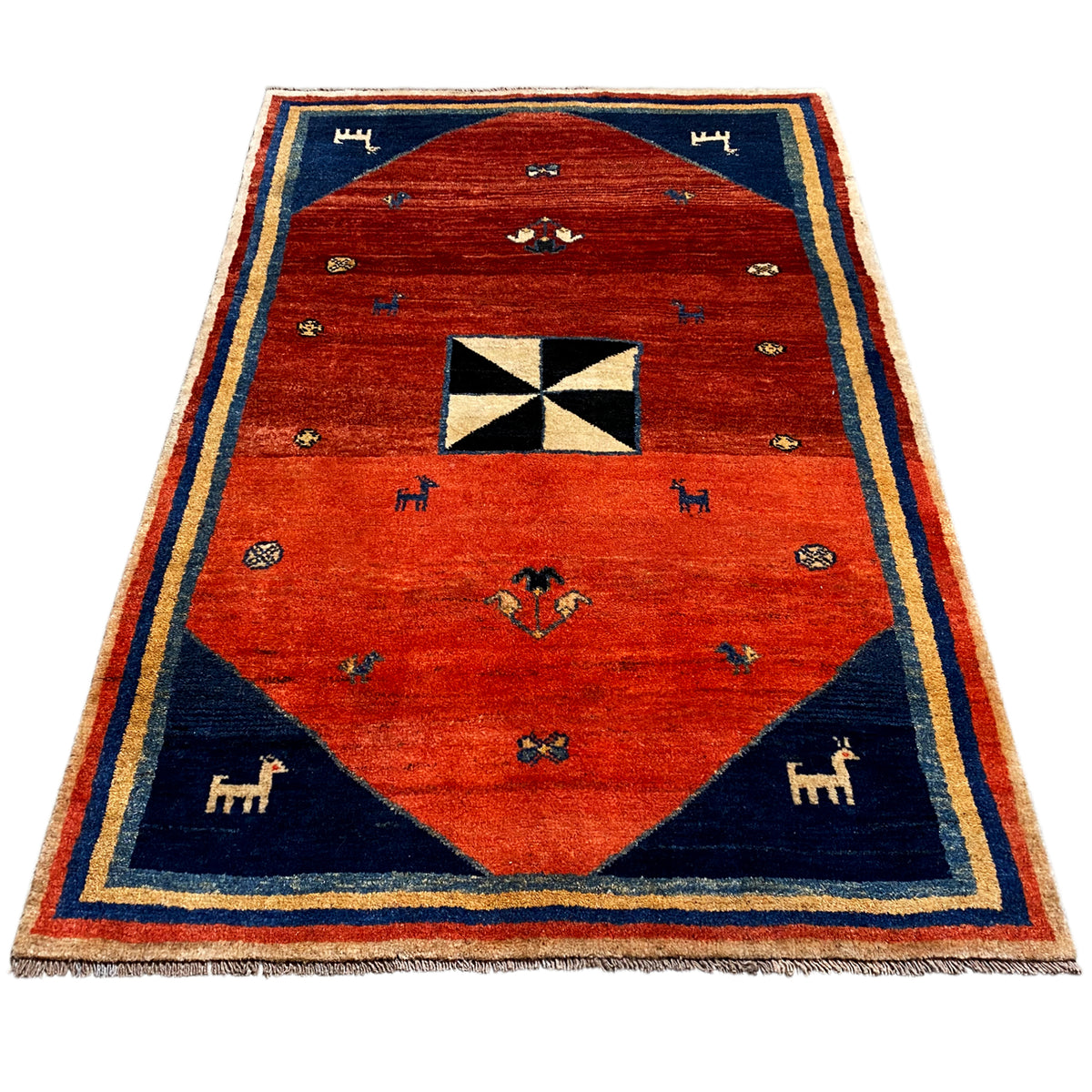 Gabbeh rug with a red field, blue angular spandrels, animal motifs, and an octagonal pattern