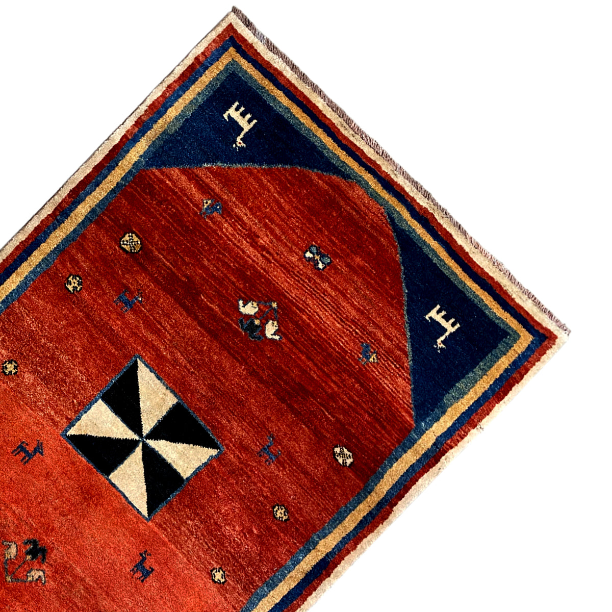 Corner of the rug: red field, blue border band, black-and-white octagonal pattern
