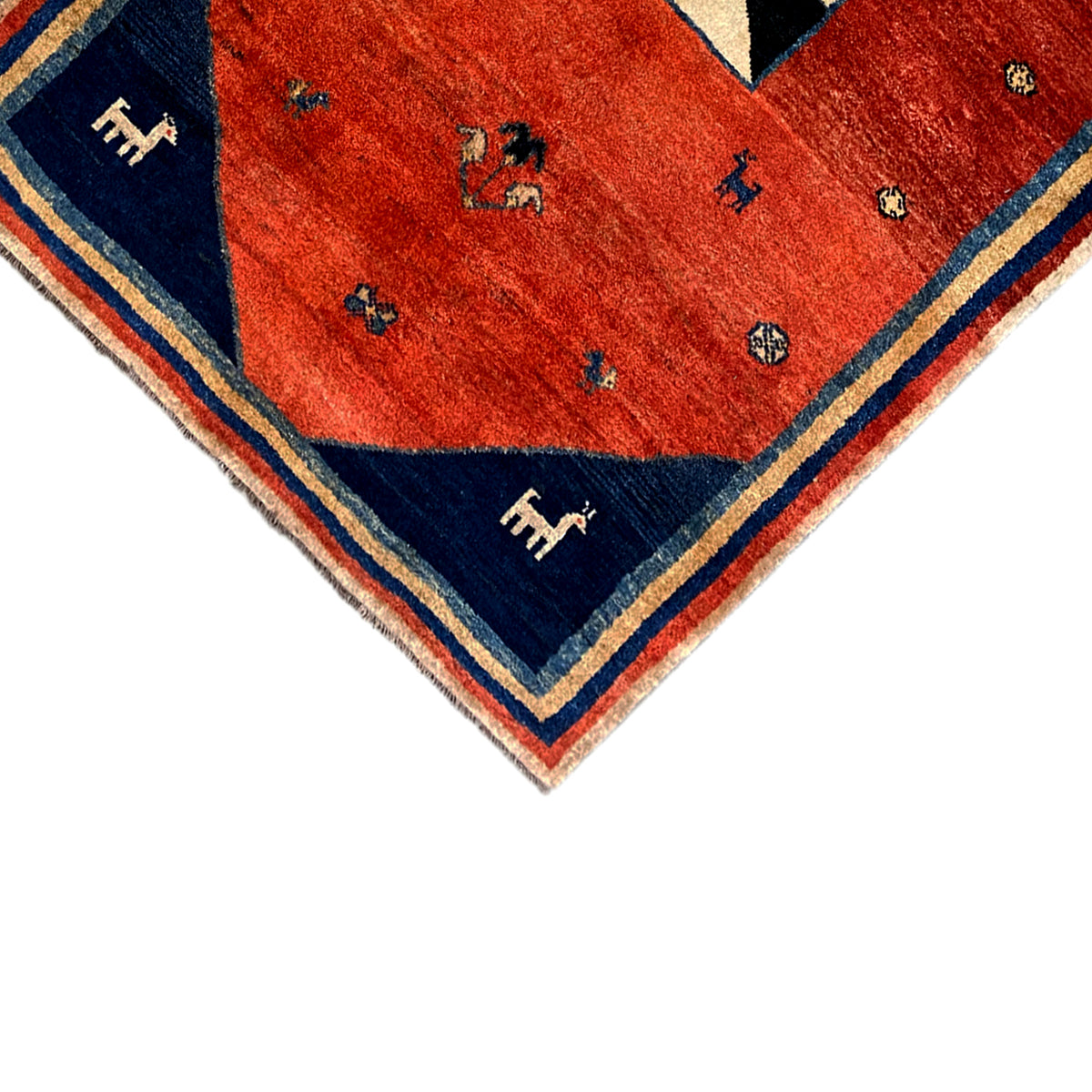 Rug corner with a red field and blue border, small animal motifs